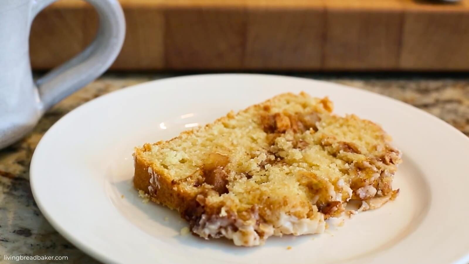 slice of glazed sourdough discard apple fritter bread with a cup of coffee