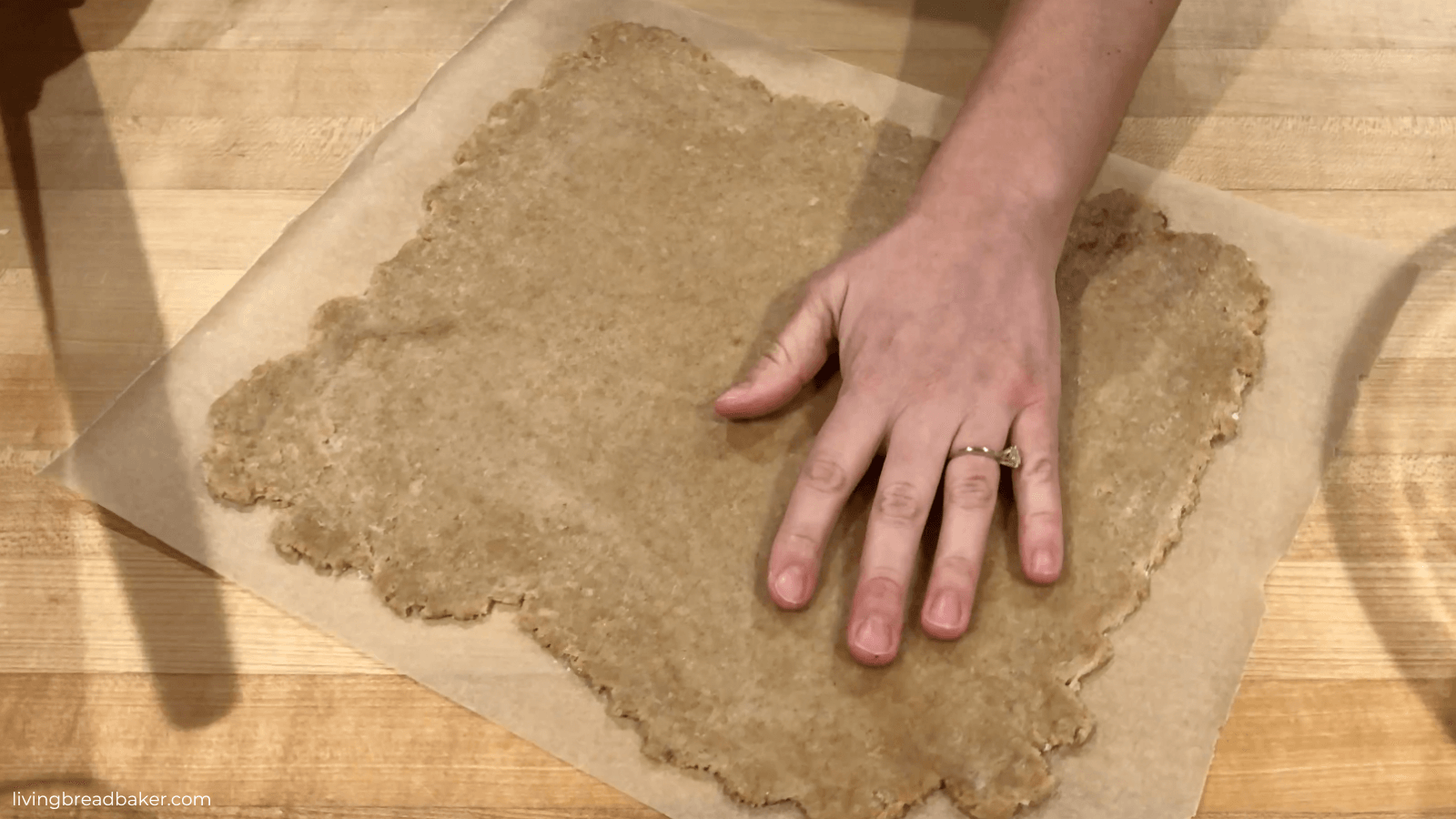 hand testing thickness of sourdough discard graham cracker dough for best sourdough discard graham crackers recipe
