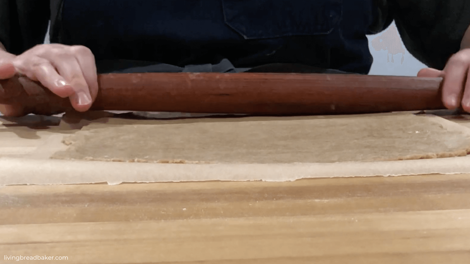 sourdough discard graham cracker dough being rolled with a rolling pin for best sourdough discard graham crackers recipe